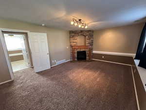 Unfurnished living room with dark carpet and a fireplace