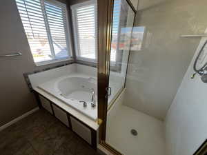 Bathroom featuring a whirlpool tub and a stall shower