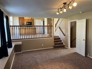 Unfurnished room with stairs and carpet flooring