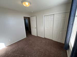 Unfurnished bedroom featuring carpet floors and a closet