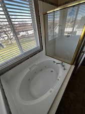 Full bath with a jetted tub and a shower stall