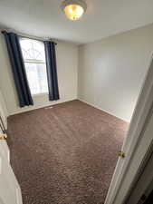 Carpeted empty room featuring baseboards