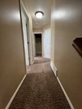 Corridor with carpet flooring and a textured ceiling