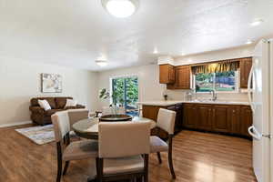 Dining space with dark wood-style flooring, a textured ceiling, and recessed lighting