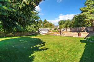 Fenced backyard with a shed and view of scattered trees