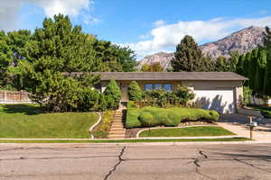 View of front facade featuring a mountain view, driveway, and a garage