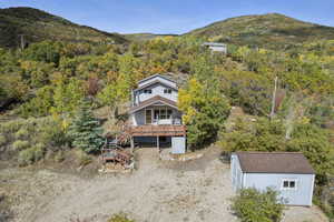 View of subject property featuring mountains and a heavily wooded area