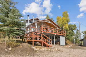 Rear view of property with a wooden deck and stairs
