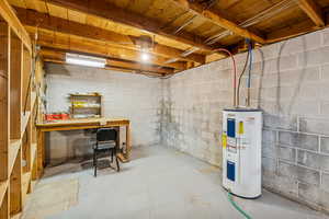 Unfinished below grade area featuring water heater