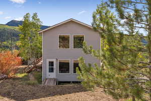 Rear view of house with stairway and a mountain view