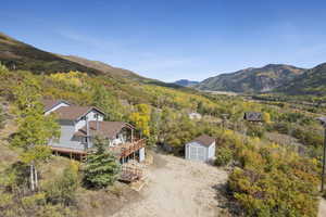 View from above of property featuring a mountainous background and a forest