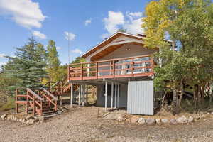 Rear view of house with a wooden deck and stairway