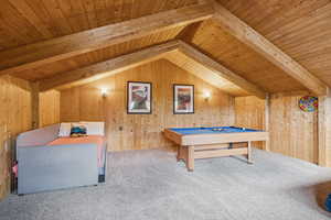 Playroom with carpet floors, wooden ceiling, pool table, and wooden walls