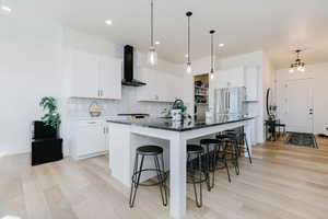 Kitchen with decorative backsplash, a breakfast bar area, hanging light fixtures, and recessed lighting