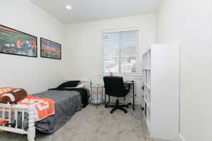 Bedroom featuring light carpet, recessed lighting, and an office area