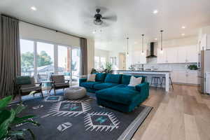 Living area with light wood-style floors, recessed lighting, and a ceiling fan