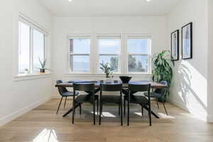 Dining space with light wood finished floors and recessed lighting
