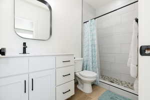 Full bathroom with vanity, a shower stall, and light wood finished floors