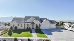 View of front of house featuring a porch, roof with shingles, a mountain view, driveway, and an attached garage