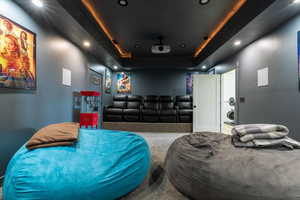 Cinema featuring a raised ceiling, carpet flooring, and recessed lighting