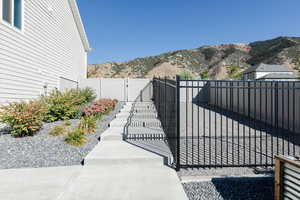 Gate featuring a mountain view and a fenced backyard