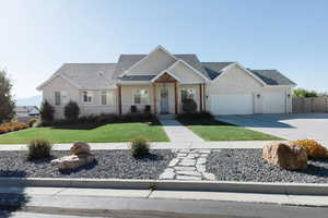 View of front of home featuring concrete driveway, covered porch, roof with shingles, and a garage