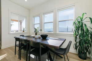 Dining room with light wood finished floors and recessed lighting