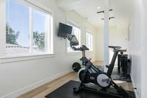 Workout area featuring light wood-style floors and recessed lighting