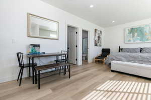 Bedroom with light wood-style flooring, recessed lighting, and ensuite bath