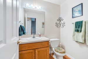 Half bathroom with vanity and wood finished floors