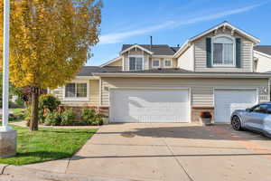 Traditional home featuring brick siding, concrete driveway, and a garage