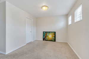 Carpeted empty room featuring baseboards