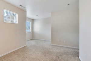 Spare room with light colored carpet and a textured ceiling