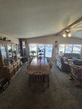 Dining area featuring dark carpet, a ceiling fan, and a textured ceiling