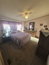Carpeted bedroom featuring ceiling fan
