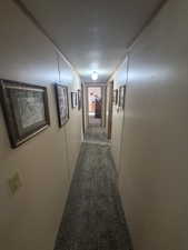 Hallway with carpet floors and a textured ceiling