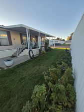 View of green lawn featuring a porch