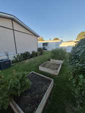 View of grassy yard with a vegetable garden
