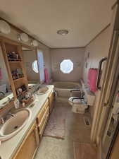 Bathroom featuring a bath and double vanity