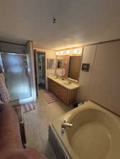 Full bathroom with a stall shower, double vanity, and a garden tub