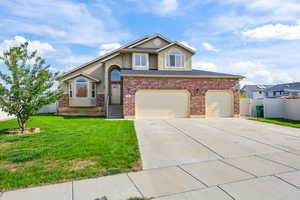 View of front of home with driveway, stucco siding, and brick siding