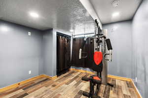 Workout room featuring wood finished floors and a textured ceiling