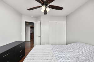 Bedroom with dark wood finished floors, a closet, and ceiling fan