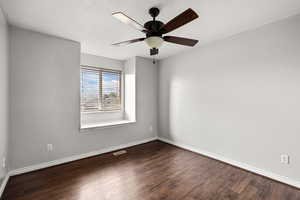 Spare room with wood finished floors, a ceiling fan, and a textured ceiling