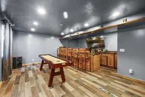 Game room featuring a textured ceiling, light wood finished floors, and recessed lighting