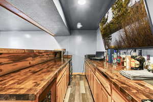Kitchen featuring wood counters, light wood-type flooring, and a textured ceiling
