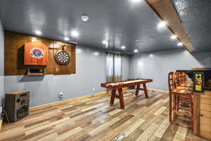 Game room featuring light wood-style floors, a textured ceiling, and recessed lighting