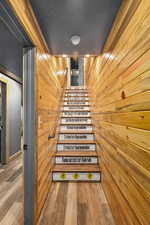 Stairway with wood finished floors, a sauna / steam room, and a textured ceiling