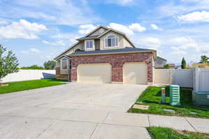 Traditional-style home with driveway, brick siding, and roof with shingles