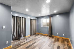 Unfurnished room featuring a textured ceiling, light wood-style flooring, and recessed lighting